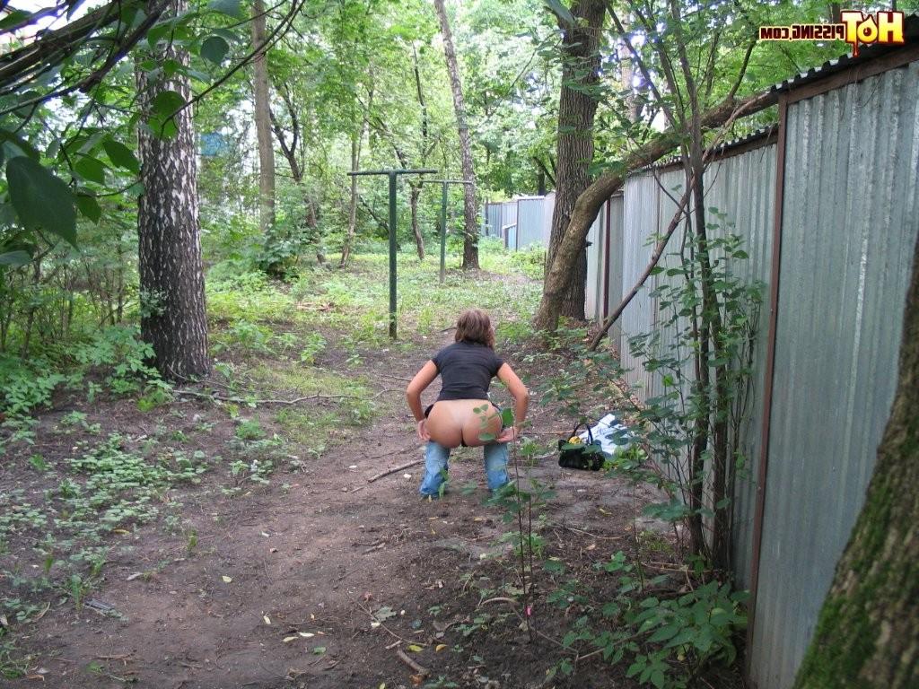 15P Spy camera shots of a gal in jeans as she does a leak behind a garage