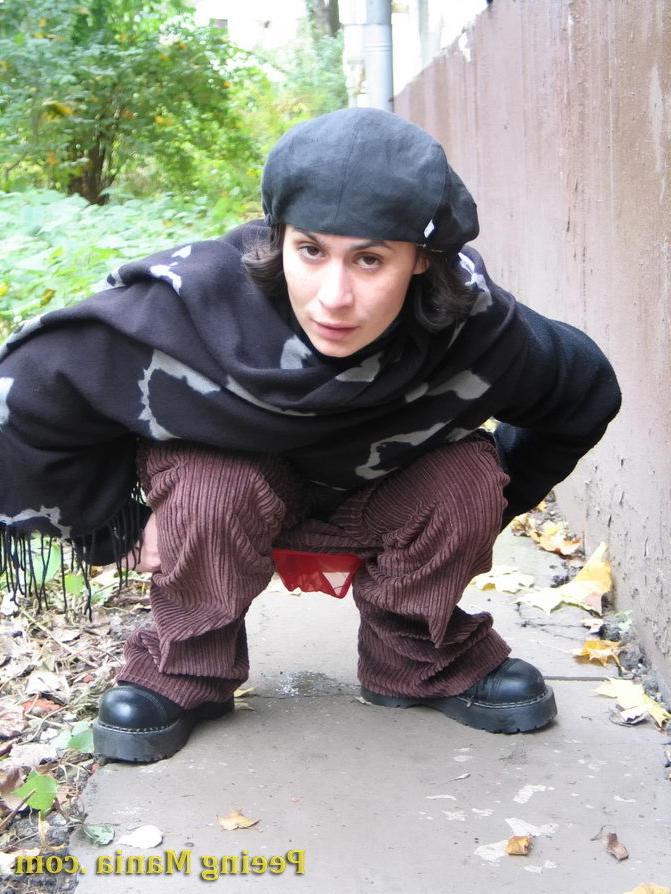 15P Stylishly dressed pretty woman does a leak behind a building in autumn