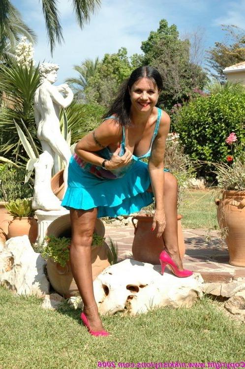 15P Mature stocking model Nikki posing outside