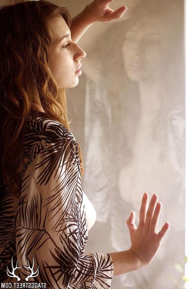 15P Shay Laren stands in the window with sunlight pouring on her boobs