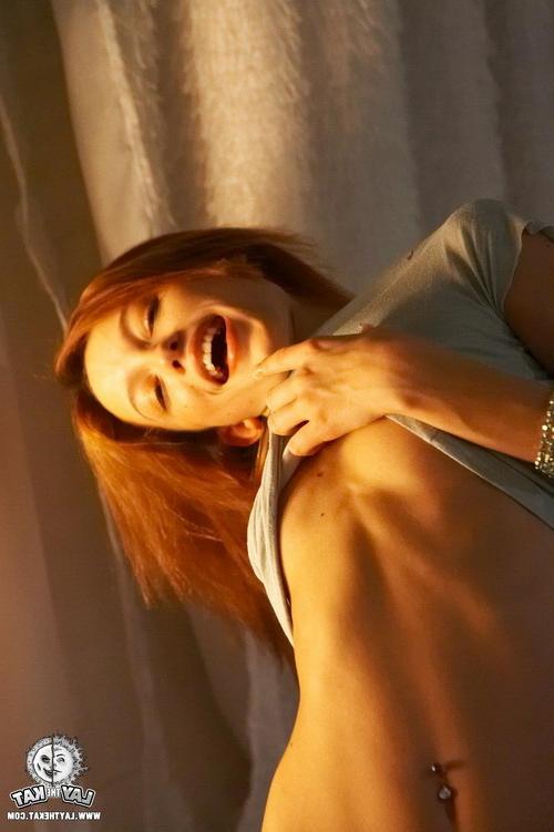17P Seductive young redhead posing in a dimmed intimate light