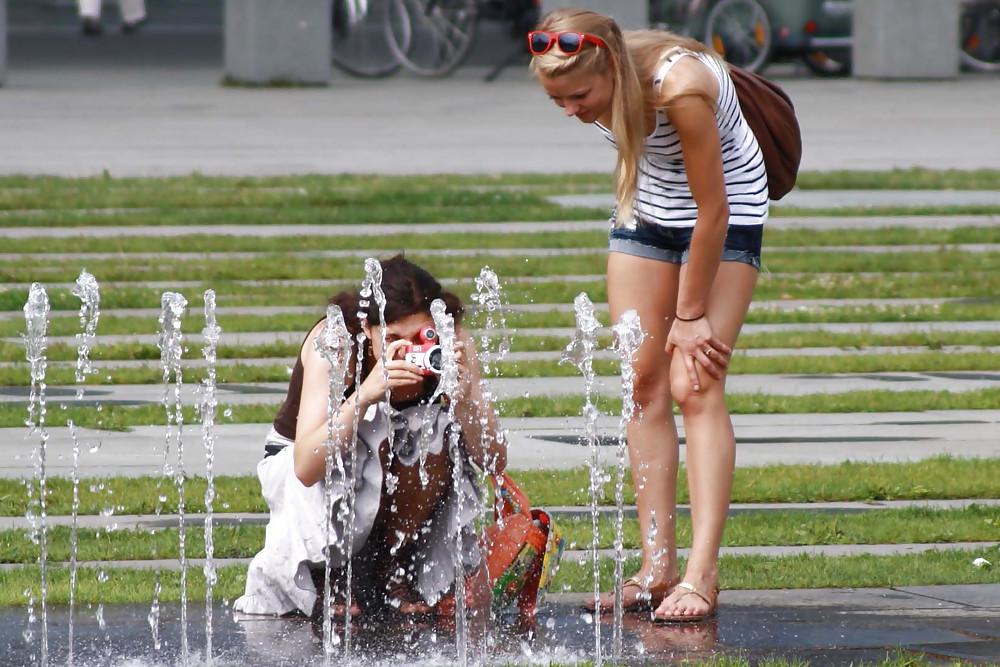 12P Two sexy and young girls takes photos on a fountain