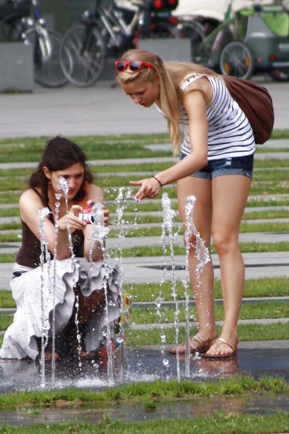 12P Two sexy and young girls takes photos on a fountain