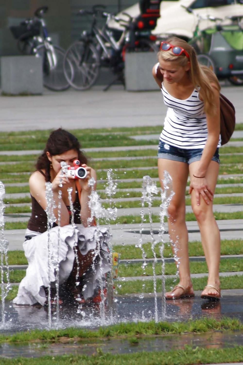 12P Two sexy and young girls takes photos on a fountain