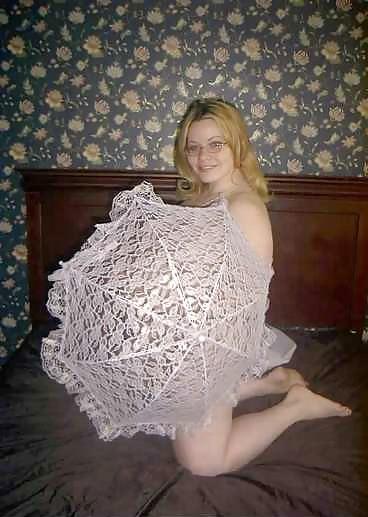 22P Pregnant blonde posing with an unbrella on her bed