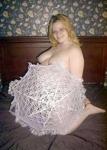 22P Pregnant blonde posing with an unbrella on her bed