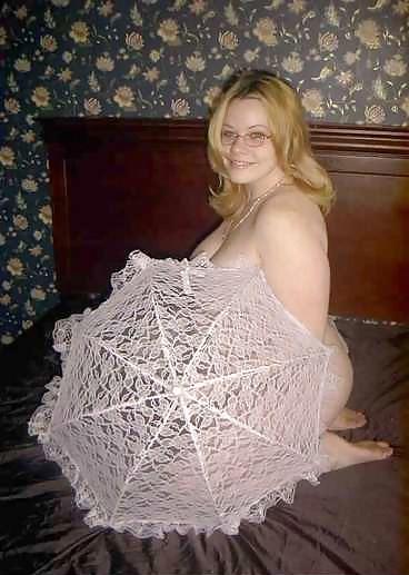 22P Pregnant blonde posing with an unbrella on her bed