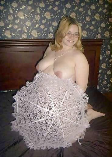 22P Pregnant blonde posing with an unbrella on her bed