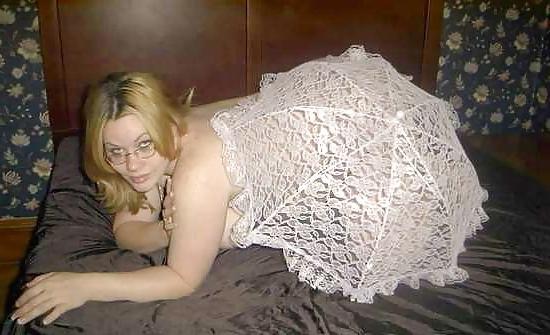 22P Pregnant blonde posing with an unbrella on her bed
