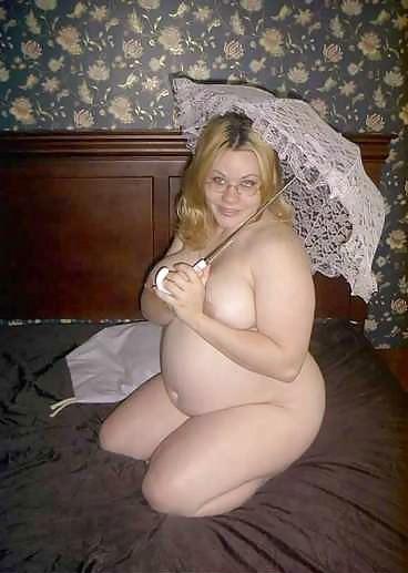 22P Pregnant blonde posing with an unbrella on her bed