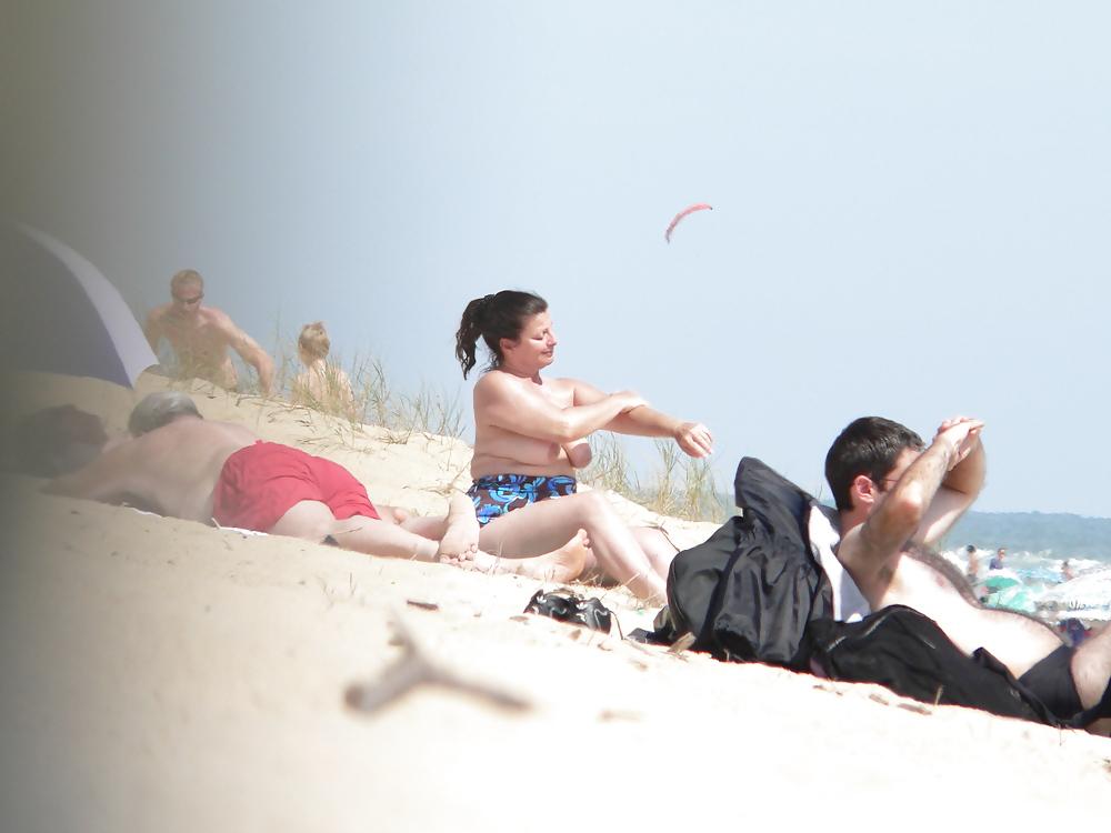 15P Chubby beach topless brunette