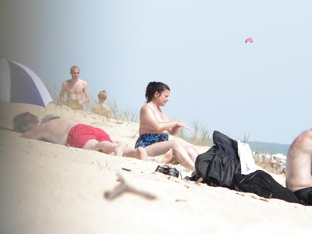 15P Chubby beach topless brunette