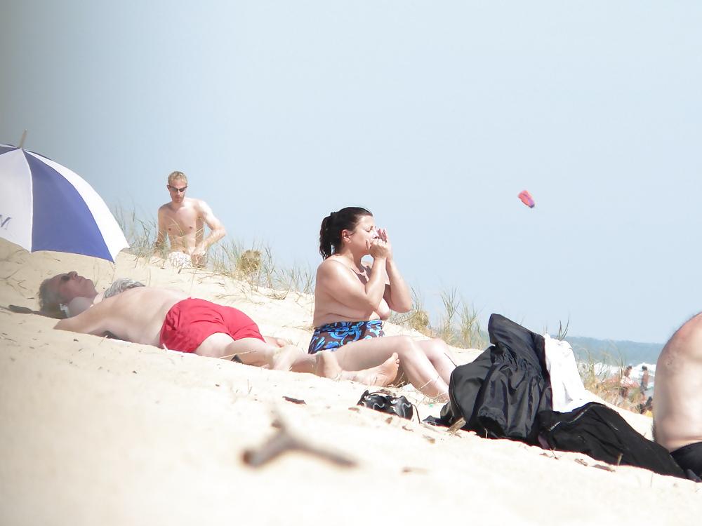 15P Chubby beach topless brunette