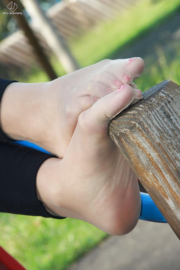 16P Lovely Christelle is showing her fine feet on a children playground