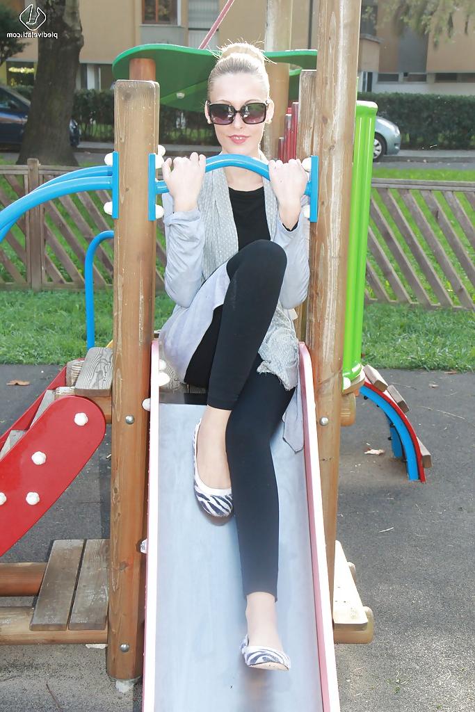 16P Lovely Christelle is showing her fine feet on a children playground