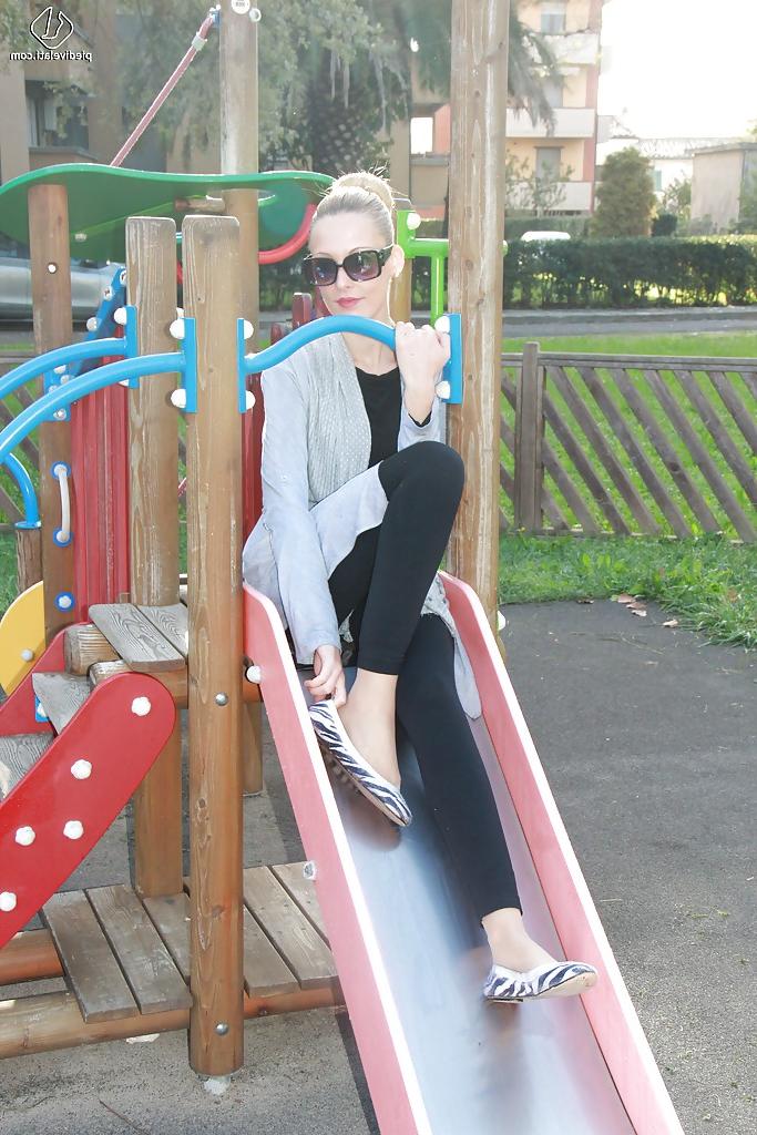 16P Lovely Christelle is showing her fine feet on a children playground