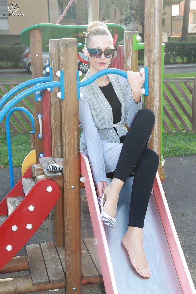 16P Lovely Christelle is showing her fine feet on a children playground