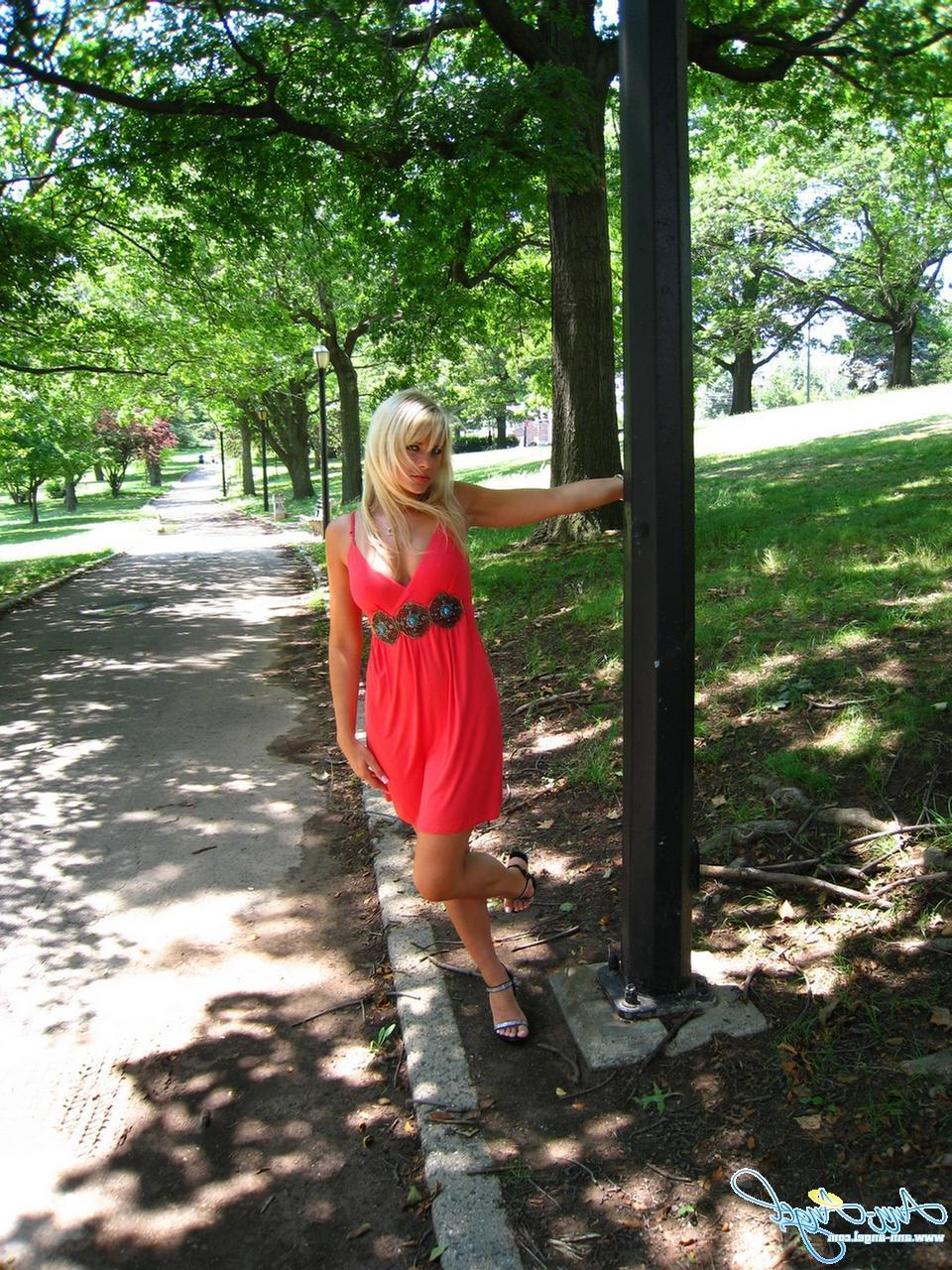15P Pictures of Ann Angel teasing in a red dress at the park