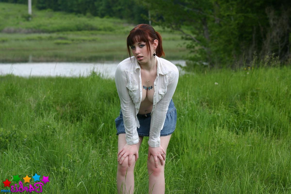 12P Barbie shows off her perky boobs as she unbuttons her top outside in the grass field
