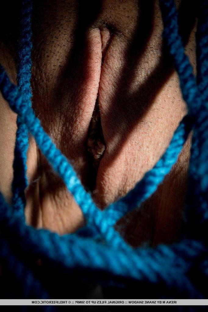 16P A tangled mess of blue ropes envelop Irena's body as she masturbates on top of the cushioned sofa.