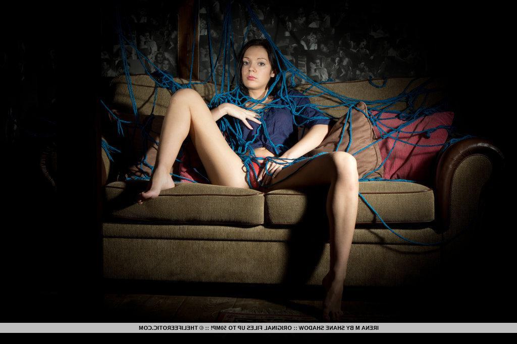 16P A tangled mess of blue ropes envelop Irena's body as she masturbates on top of the cushioned sofa.