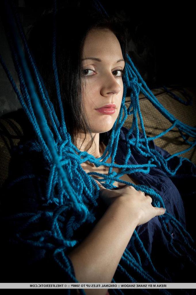 16P A tangled mess of blue ropes envelop Irena's body as she masturbates on top of the cushioned sofa.