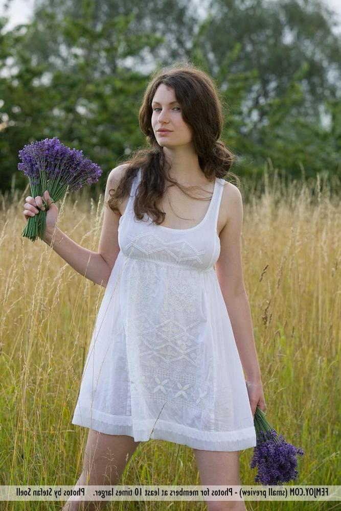 12P Pictures of busty girl Susann getting naked in the field