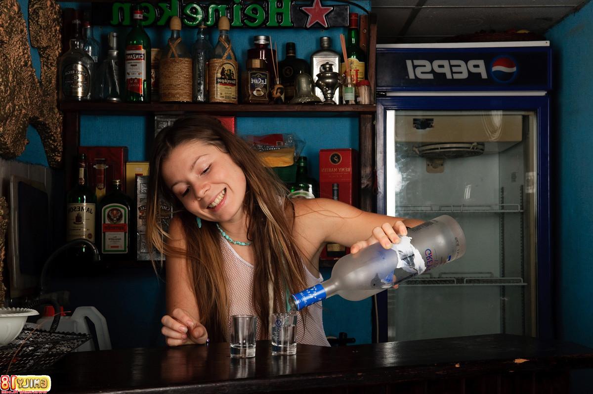15P Young model Emily 18 pours a shot while in her sheer white lingerie and throws i