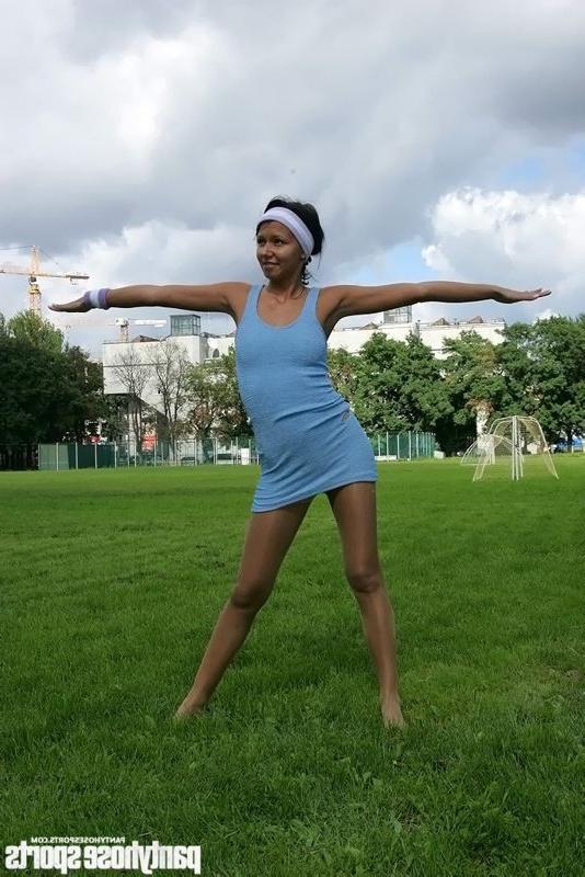 15P Brunette in shiny pantyhose stretching outdoors