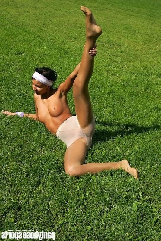 15P Brunette in shiny pantyhose stretching outdoors