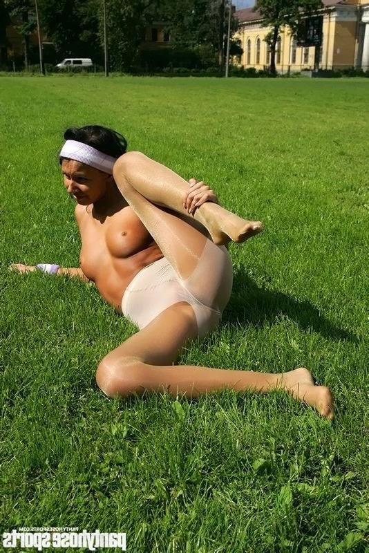 15P Brunette in shiny pantyhose stretching outdoors