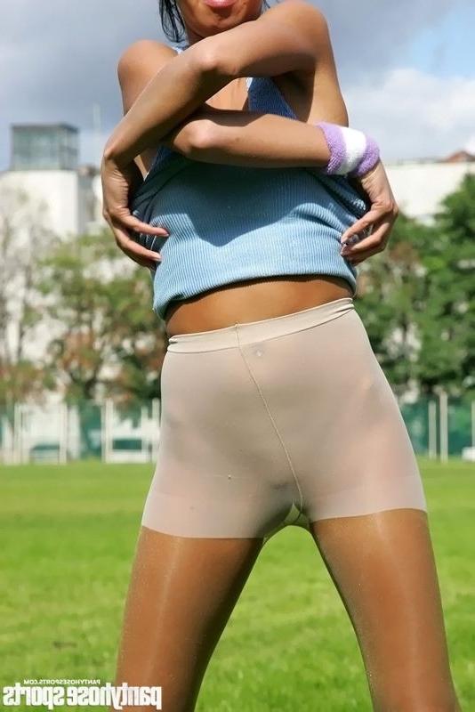 15P Brunette in shiny pantyhose stretching outdoors