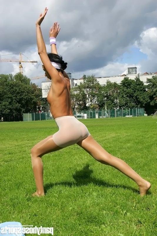 15P Brunette in shiny pantyhose stretching outdoors
