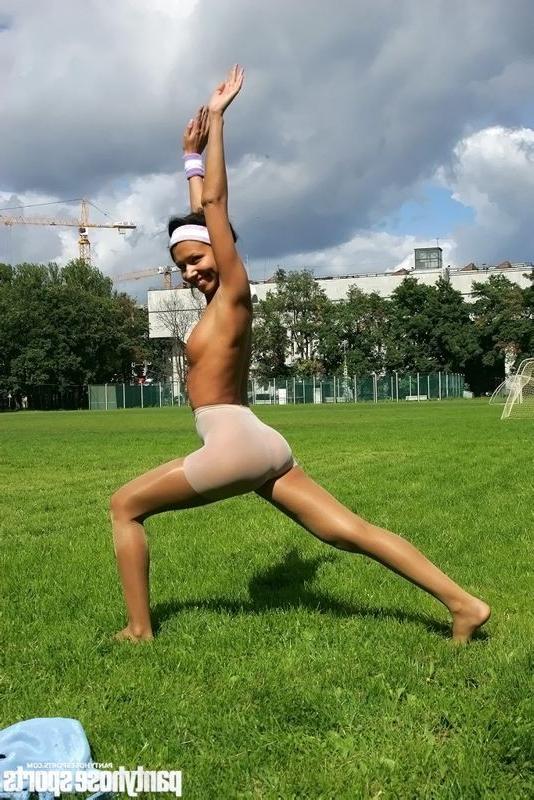 15P Brunette in shiny pantyhose stretching outdoors