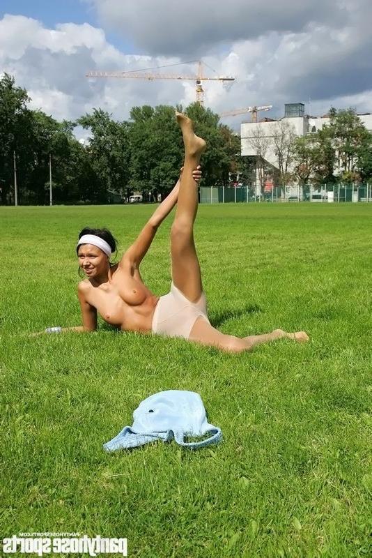 15P Brunette in shiny pantyhose stretching outdoors