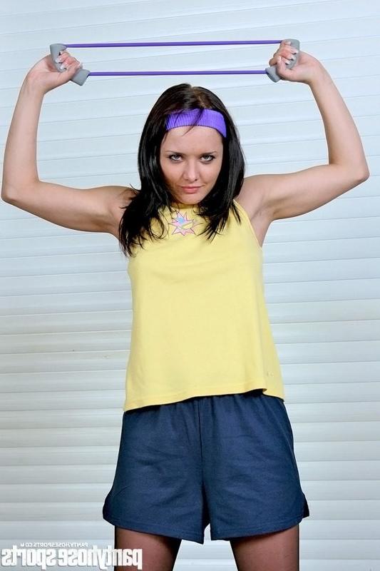 15P Brunette Gretta in pantyhose working out with stretch expander