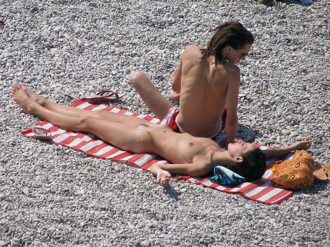 15P Brunette hottie lays around nude at the beach