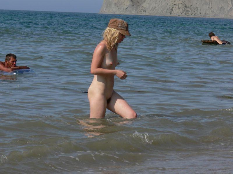 15P Brunette nudist strips down naked at a public beach