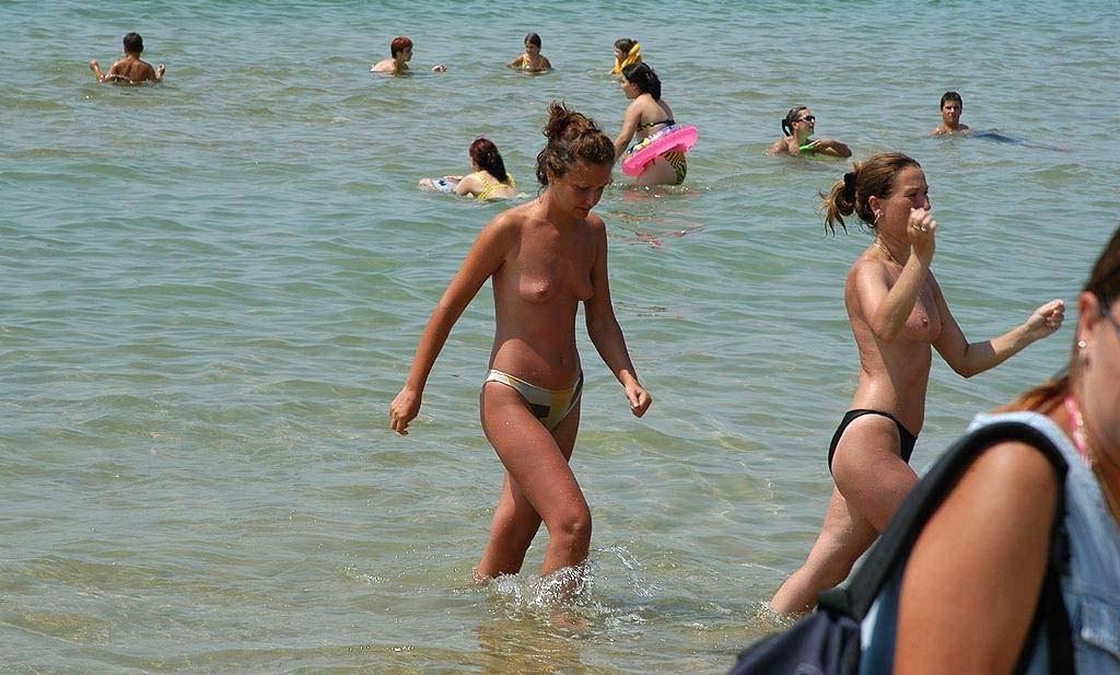 15P Perky breasted sexy babe poses on a nude beach