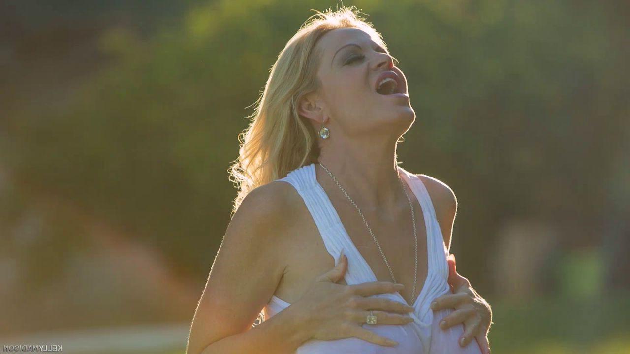 15P Die vollbusige MILF Kelly Madison vergnügt sich allein in ihrem Garten