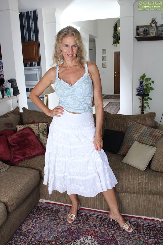 15P Busty blonde housewife Cally Jo fingers her pussy on the sofa.