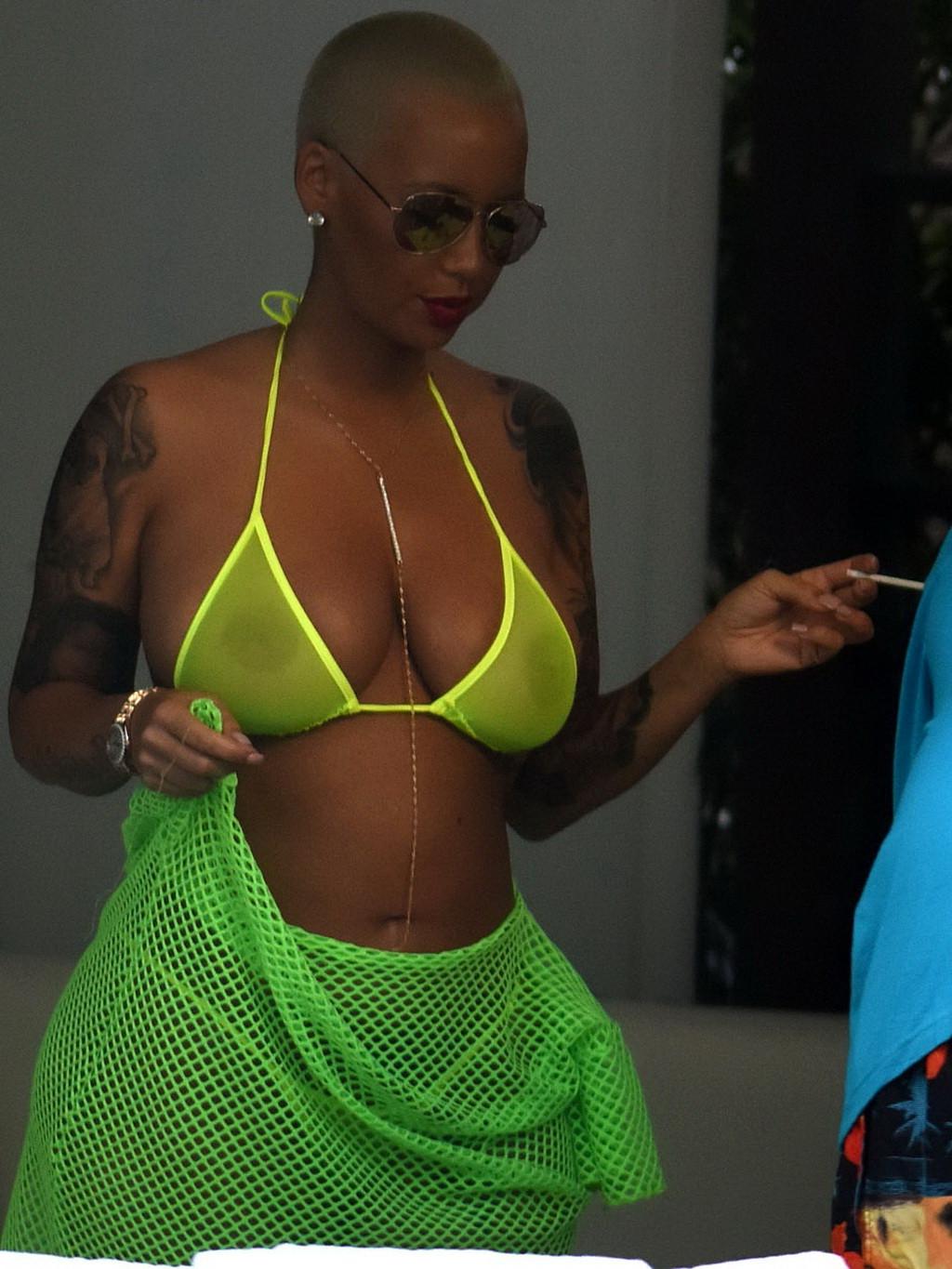 16P Amber Rose shows off her big boobs and ass wearing a see through yellow thong bi