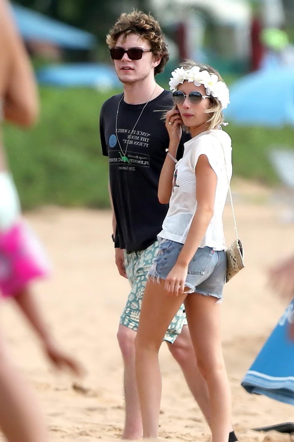16P Emma Roberts wearing bikini top and shorts on a beach in Maui