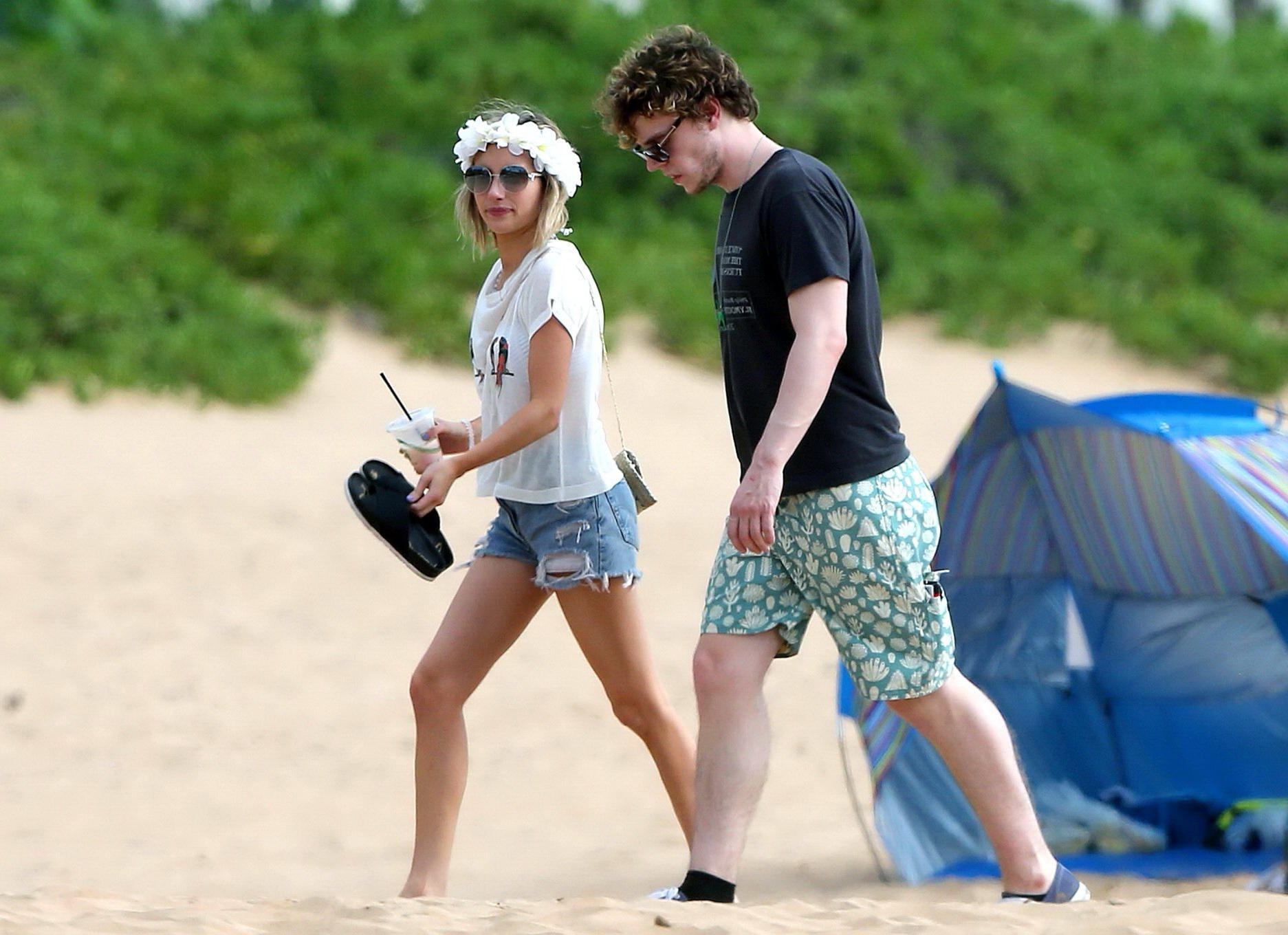 16P Emma Roberts wearing bikini top and shorts on a beach in Maui