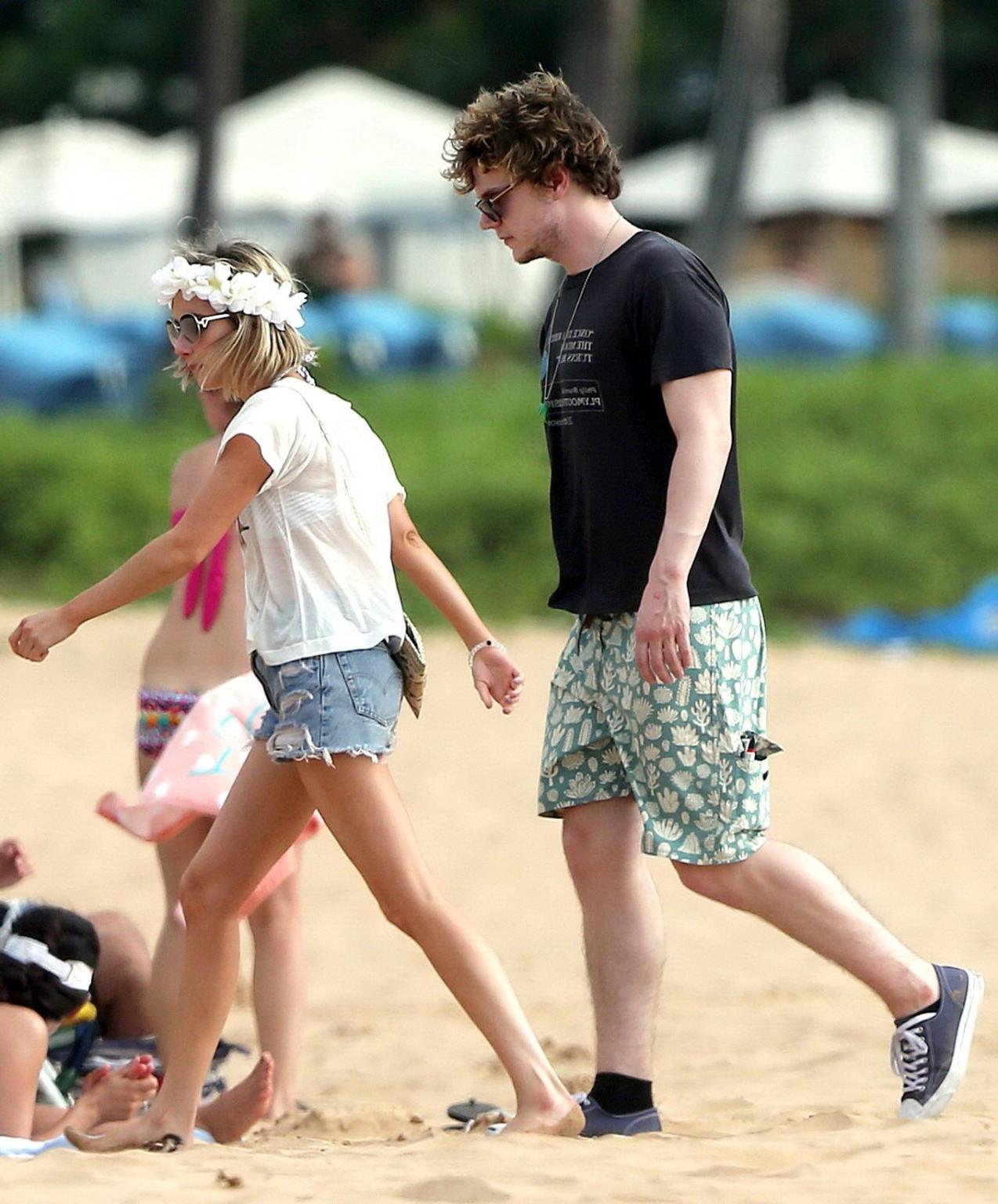 16P Emma Roberts wearing bikini top and shorts on a beach in Maui