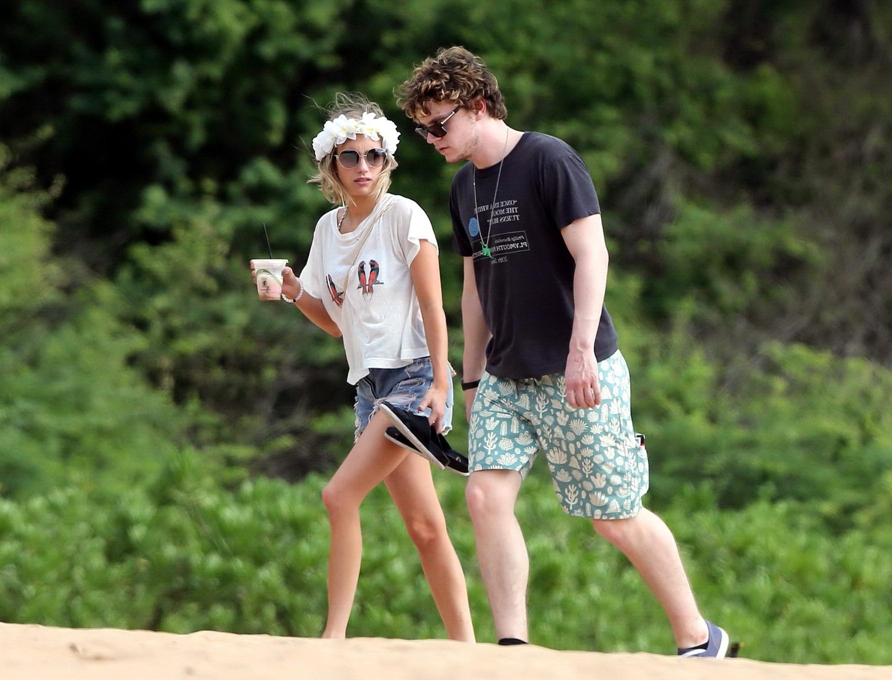 16P Emma Roberts wearing bikini top and shorts on a beach in Maui