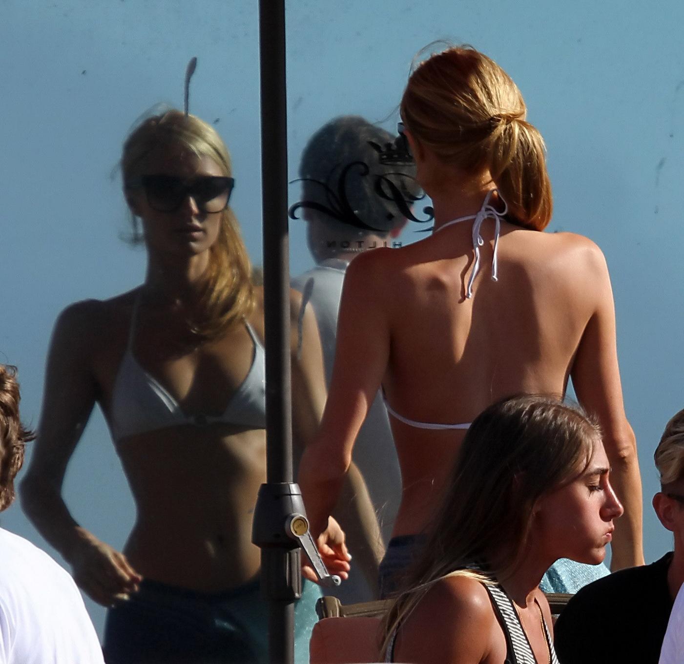 16P Paris Hilton showing her hard pokies in white transparent bikini top on the beac
