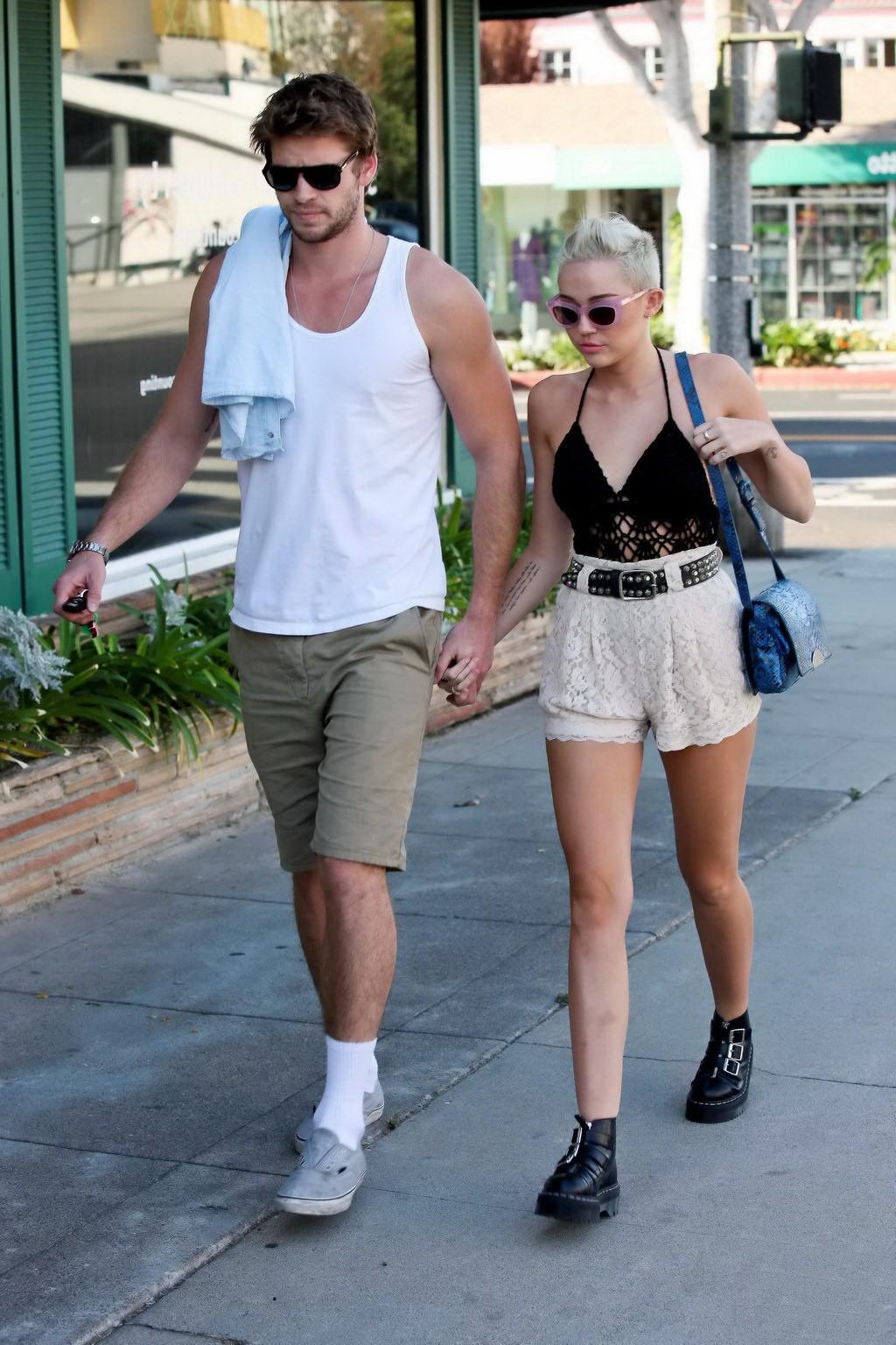 10P Miley Cyrus braless showing side boob in a partially see-through tiny top and sh