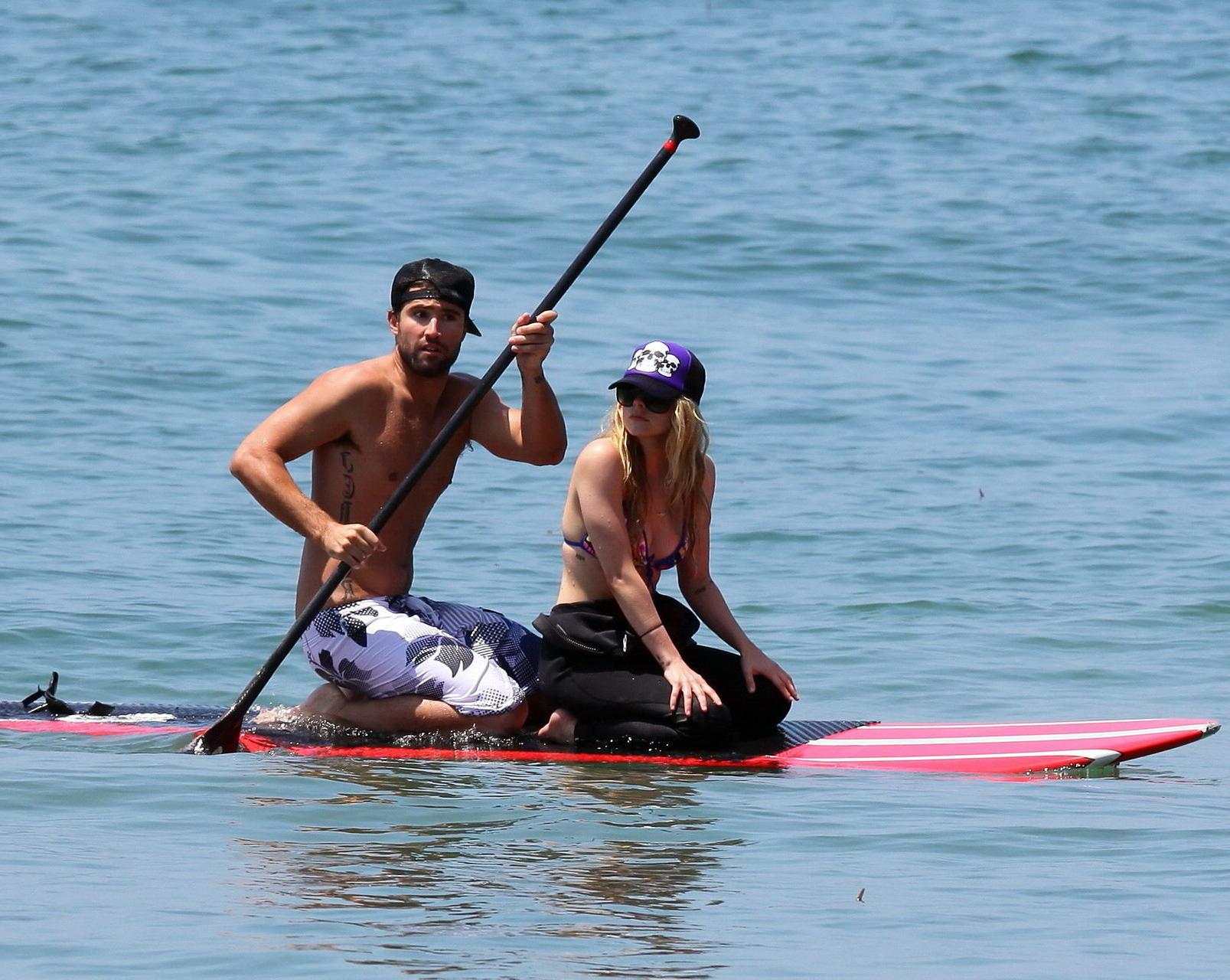 13P Avril Lavigne wearing a bikini top and a wetsuit on the beach in Malibu