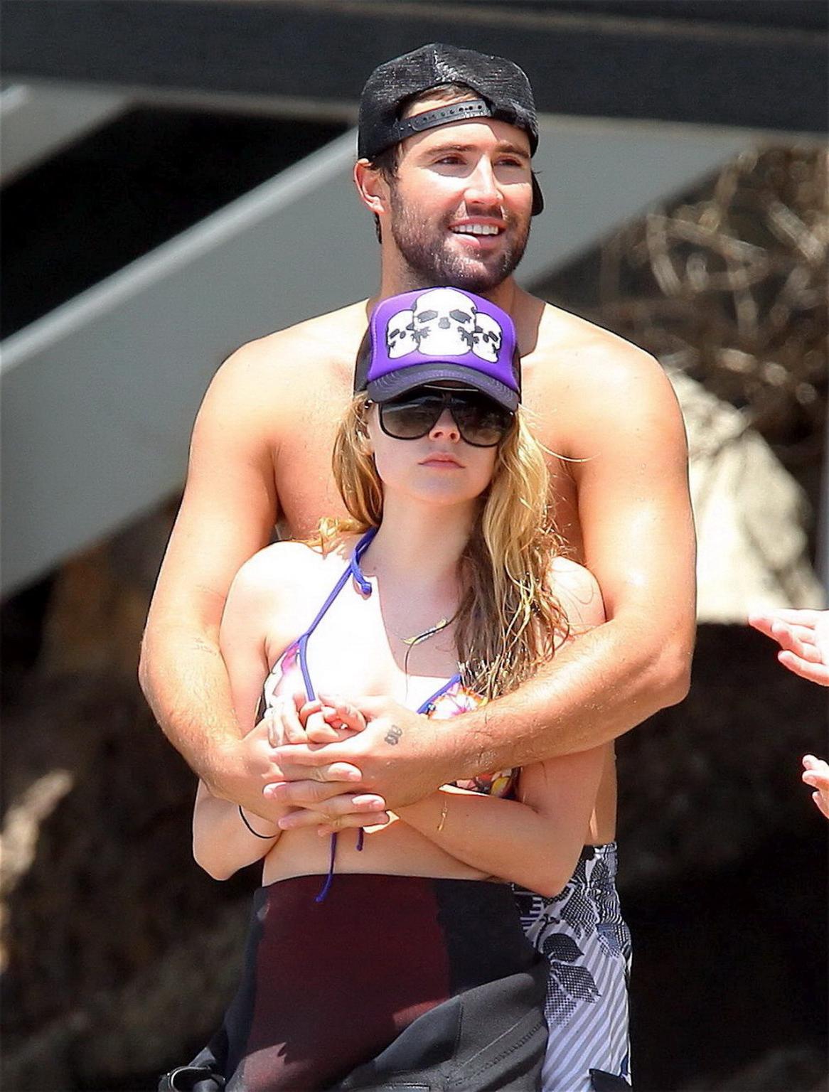 13P Avril Lavigne wearing a bikini top and a wetsuit on the beach in Malibu